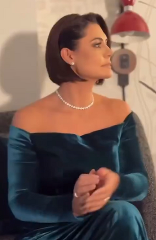 Michelle Bolsonaro sentada com seu vestido verde