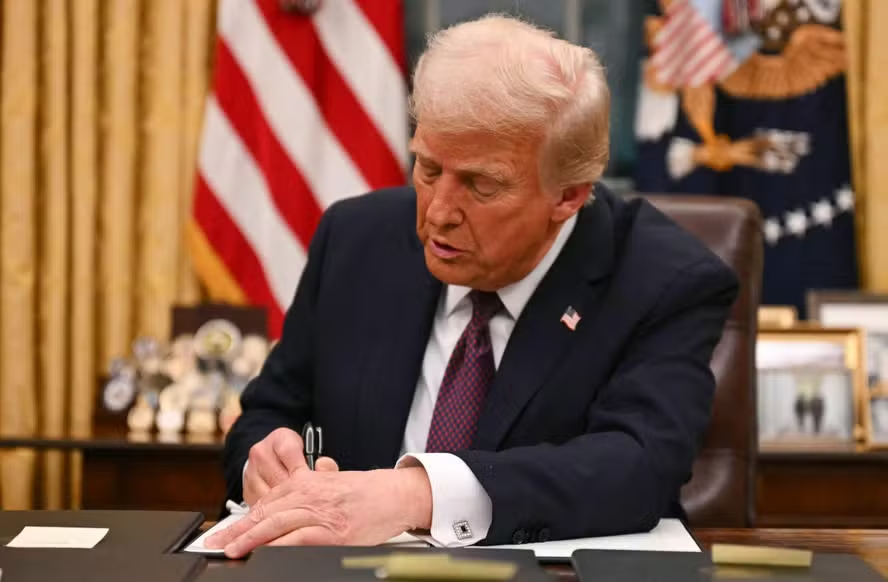 Donald Trump assinando ordens executiva na mesa oval da Casa Branca